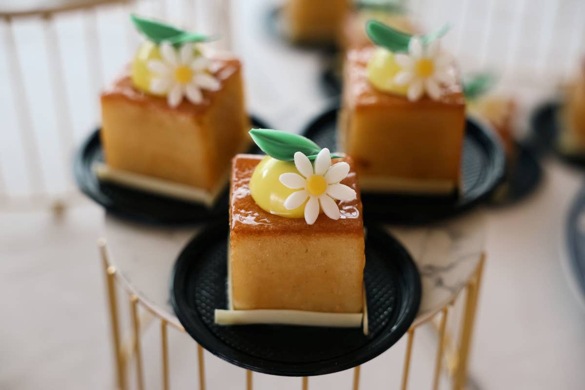 Sinfonia di Babà, un cubo ripieno di fragole poché, croccante alle mandorle e cremoso alla vaniglia, sormontato da una mousse di mandarino di Ciaculli Il miglior babà? Quello della pasticcera Alessia Rosellino