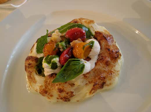 Pizza al contrario con datterini gialli e rossi, basilico, fiocchi di ricotta e fresella Pizza al contrario con datterini gialli e rossi, basilico, fiocchi di ricotta e fresella