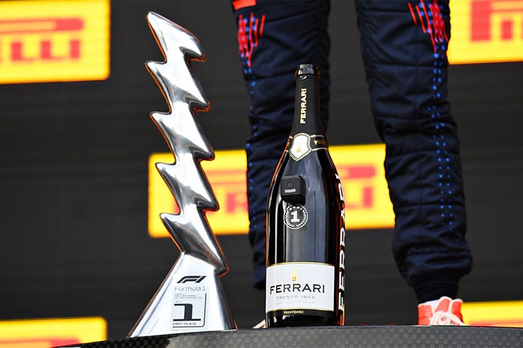 Formula 1: il trofeo e la bottiglia Ferrari sul podio di Formula 1 I vincitori stappano a Imola