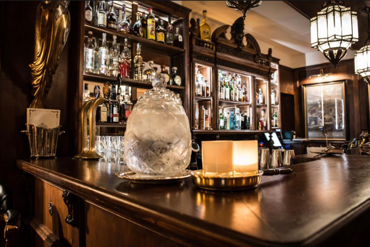 Un bellissimo bancone con una raffinata offerta di gin e whiskey  Wisdomless a Roma cocktail bar delle meraviglie