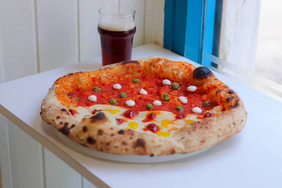 La nuova pizza firmata Favurì: una doppia base di crema di patate e sugo di pomodoro accoglie gocce di ‘nduja, crema di fiordilatte, pesto di basilico, carbocrema e pesto di pistacchi 