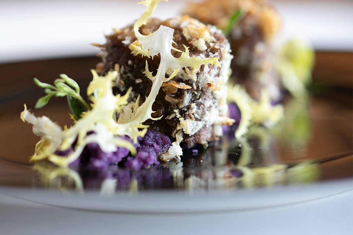 Sella D Agnello In Crosta Di Pane E Erbe Con Terra Di Patate Viola E Indivia Riccia Italia A Tavola