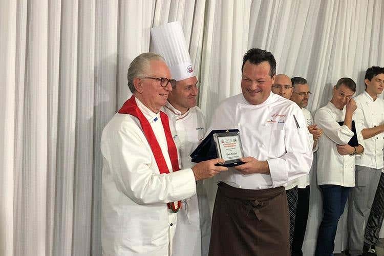 Il riconoscimento consegnato dal vice presidente Cuochi Bergamo a Ezio Gritti, al centro Andrew Regazzoni (La consapevolezza della Valle Brembana 
Tante eccellenze e la voglia di raccontarle)